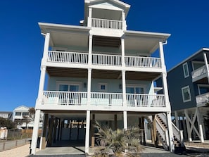 A multi-story building with balconies, a visible address number, and a clear sky.