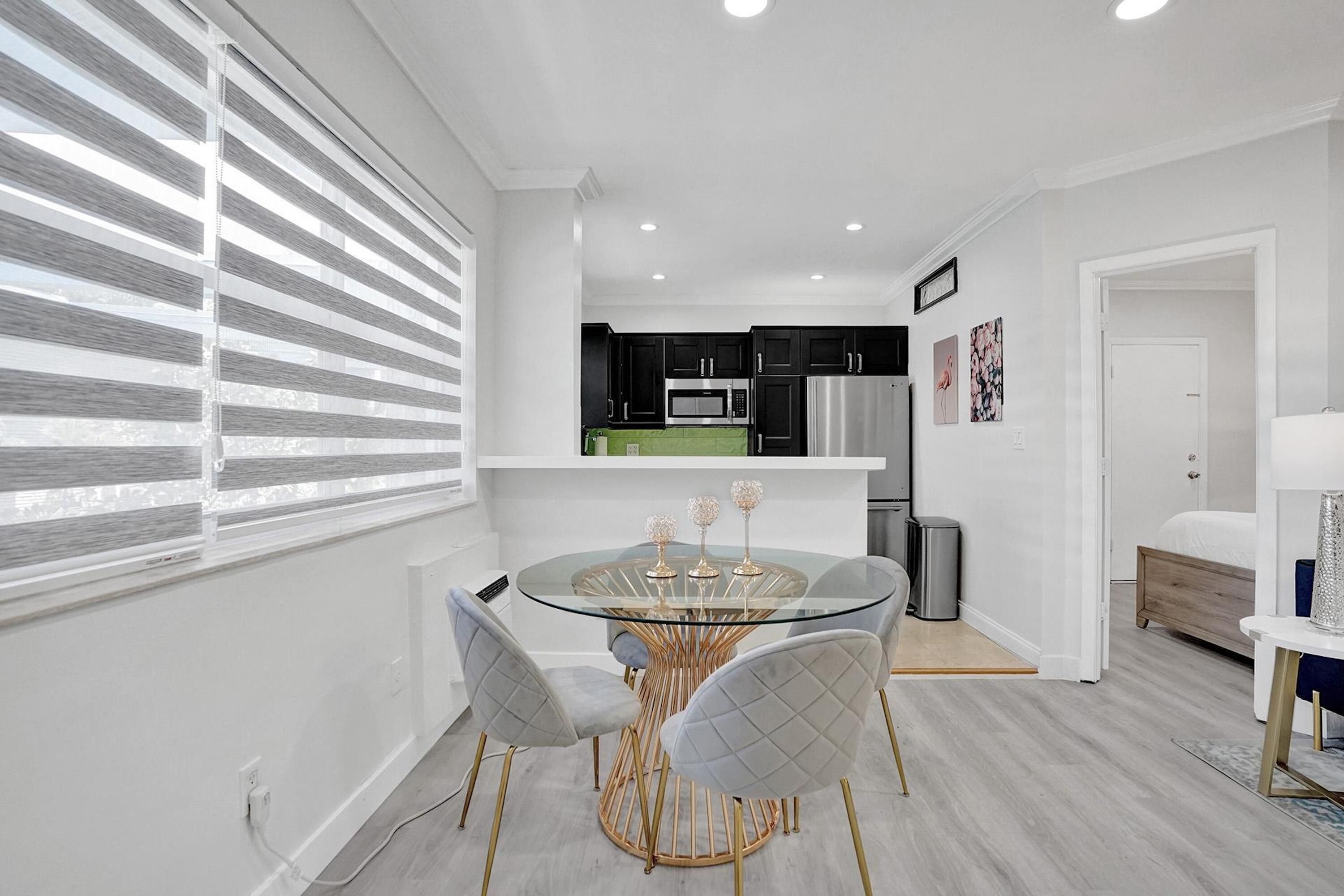 A modern kitchen with black cabinets, a stainless steel refrigerator, and a microwave.