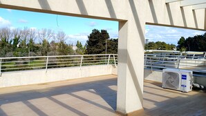 Une terrasse extérieure offrant une vue sur les arbres et un ciel dégagé.