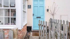 A two-room cottage with a blue door, a small garden, and a wooden fence. - 2 Riverside Cottages, Yoxford (Saxmundham)