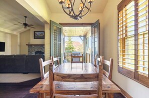 Enjoy meals in this spacious dining area with a large table and comfortable seating for six, featuring a fireplace, TV, and balcony with grill.