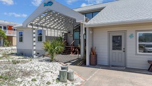 A house with a covered porch, a small garden, and a number '4' on the door. - Magnolia by the Sea- 5 BR Home with Private Pool on Holiday Isle (Destin)