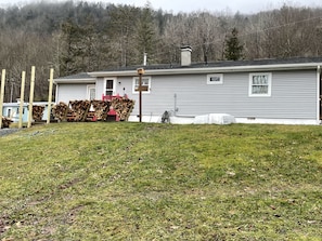 Cozy home with a fireplace, surrounded by a well-maintained lawn and a wooden fence.