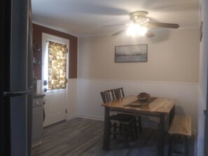 A dining area with a wooden table, chairs, and a ceiling fan. - Delaware River Retreat (Downsville)