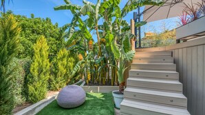 A wooden staircase leading to a deck with a view of a lush garden and a large umbrella. - VILLA GRAZIELLA 200 M FROM THE BEACH (Èze)