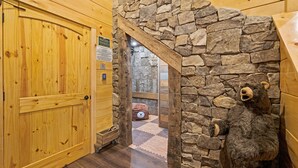 Un intérieur en bois avec une arche en pierre menant à une pièce.