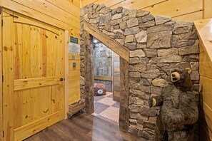 Un intérieur en bois avec une arche en pierre menant à une pièce.