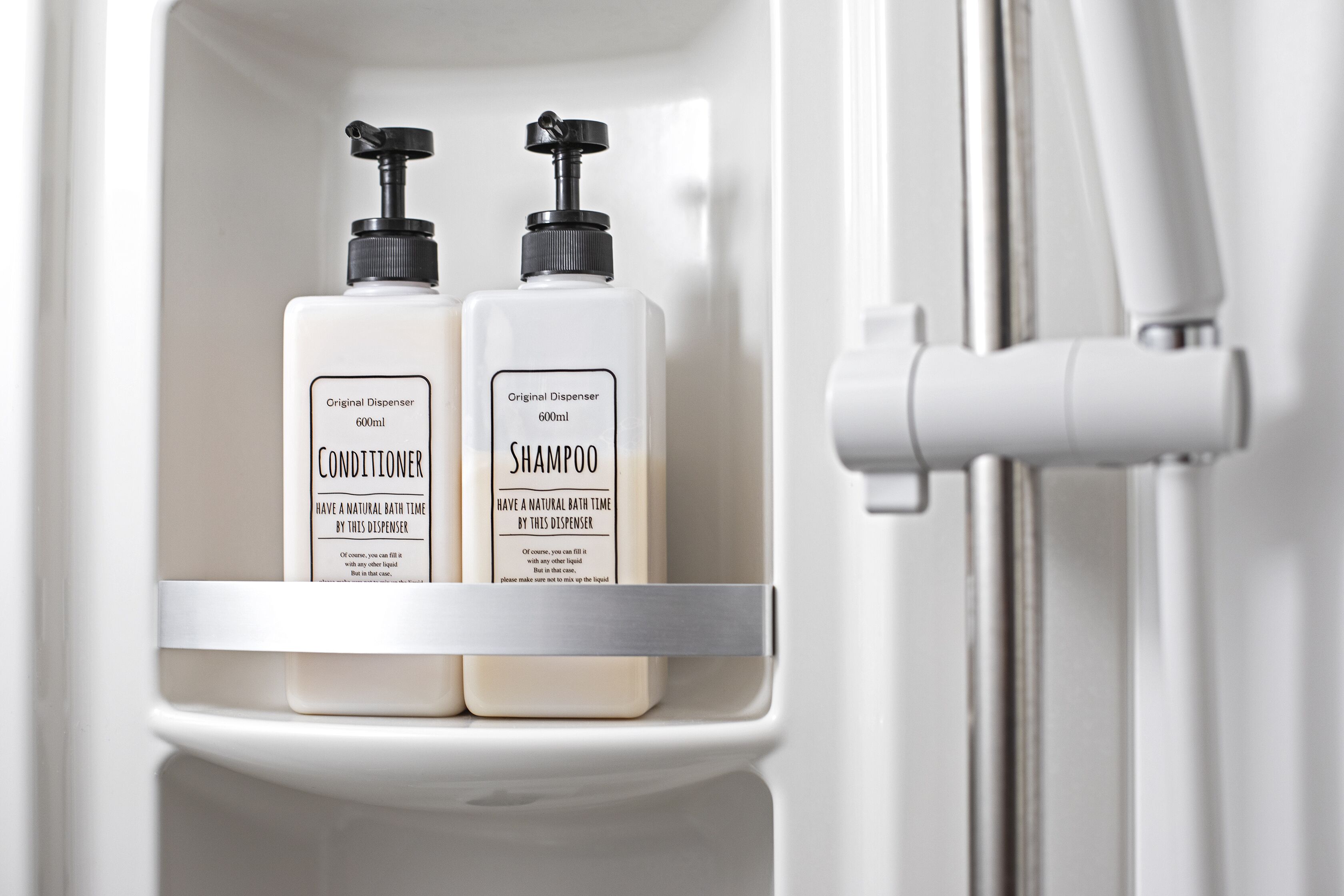 Two bottles of Original Dispenser 600ml Conditioner and Shampoo on a white shelf in a bathroom.