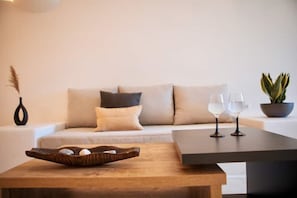 A modern living room with a sofa, a coffee table, and a potted plant.