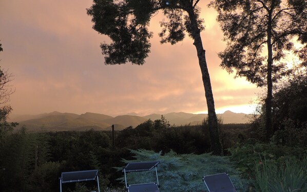 A sunset view with mountains in the background and solar panels in the foreground. - A vacation home in the woods with a breathtaking view of the Pyrenees. (Saint-Laurent-de-Neste)