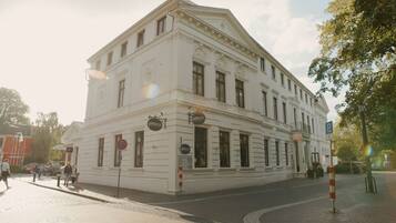 A white building with multiple windows and a sign that reads "Pittock."