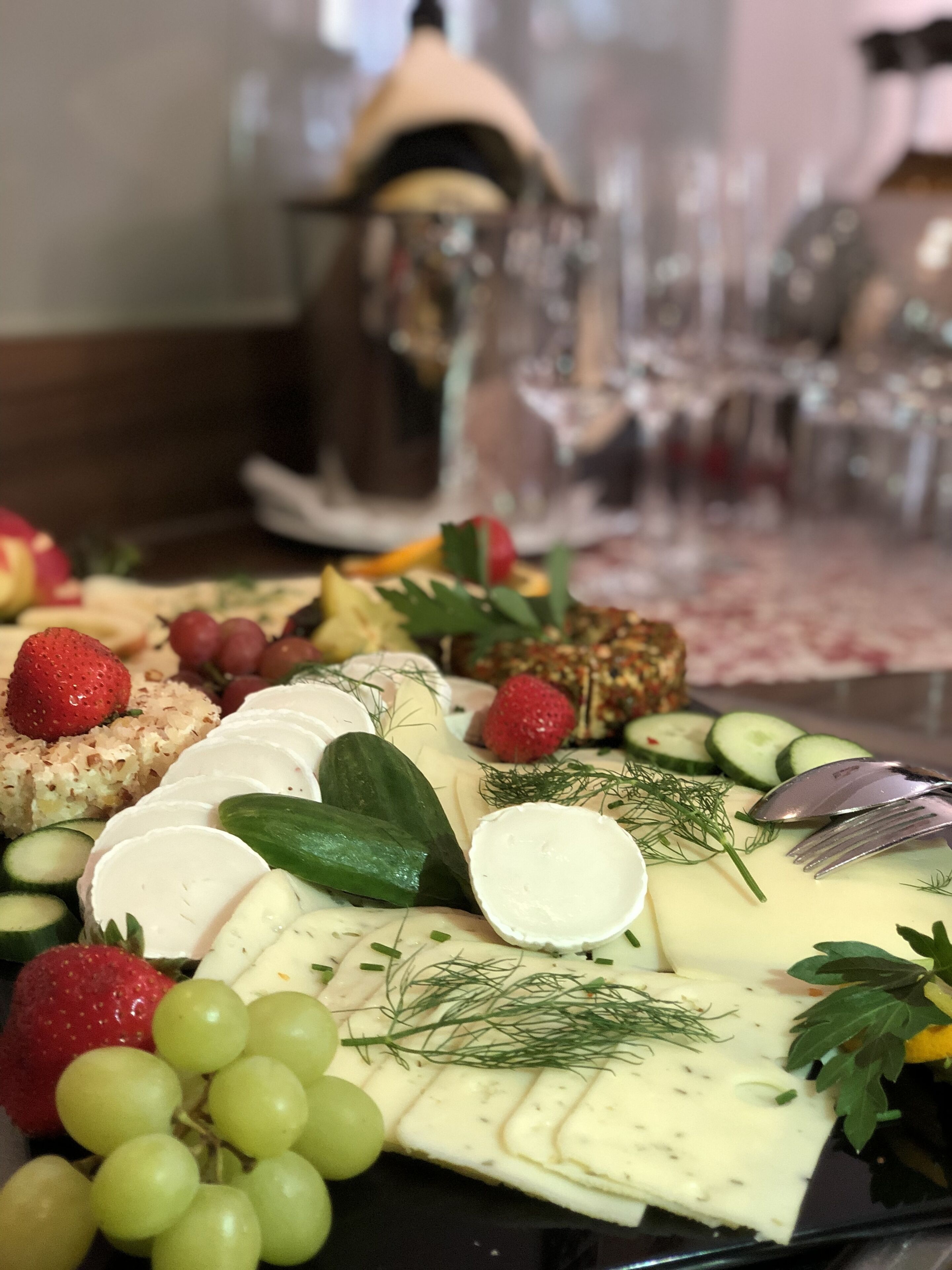 Una tabla de quesos con varios tipos de queso, frutas y verduras.