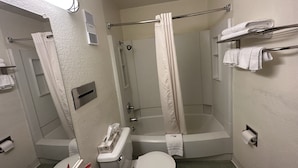 Un baño pequeño y moderno con inodoro, lavamanos y zona de ducha.