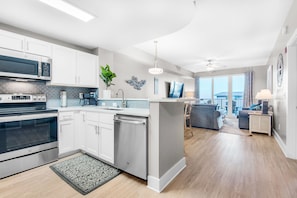 A modern kitchen with white cabinets, stainless steel appliances, and a central island.