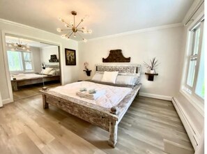 Cozy retreat with a large bed, bedside tables, and a chandelier.