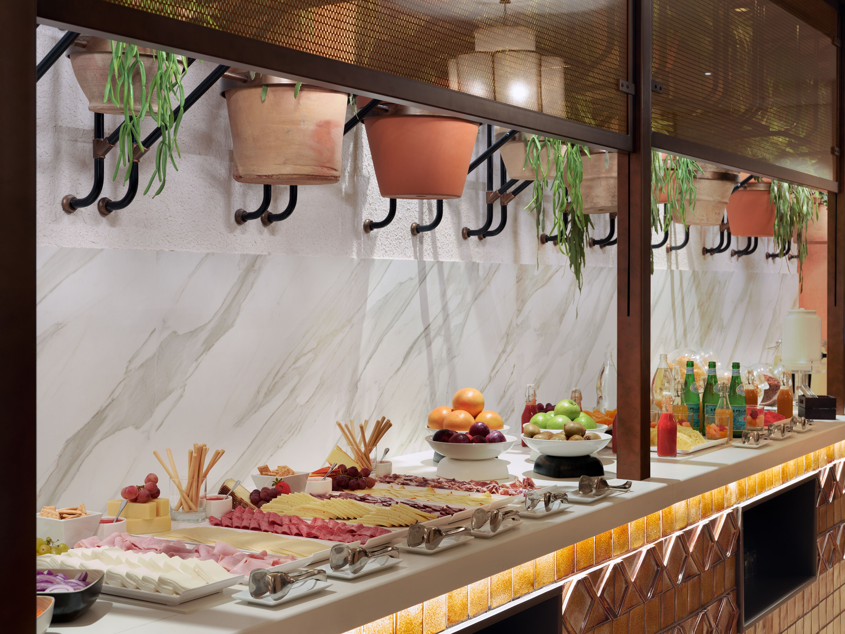 Un buffet proposant une variété de plats et un mur décoratif agrémenté de jardinières suspendues.