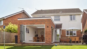 A two-story house with a patio area, a dining table, and a barbecue grill. - 4 bedroom accommodation in Shipston on Stour (Shipston on Stour)