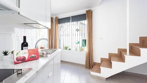A modern kitchen with a built-in stove, a sink, and a window with curtains. - Home2Book Beach & Nightlife Las Américas, Terrace (Playa de la Américas)