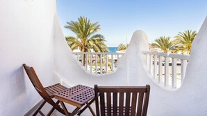 A balcony with a white railing, two wooden chairs, and a small table. - Home2Book Beach & Nightlife Las Américas, Terrace (Playa de la Américas)
