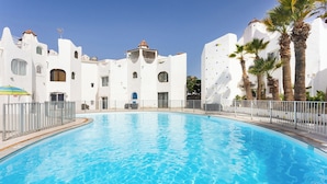 A swimming pool with white buildings in the background. - Home2Book Beach & Nightlife Las Américas, Terrace (Playa de la Américas)