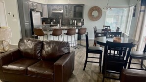 A modern kitchen with dark cabinets, a central island, and bar stools.