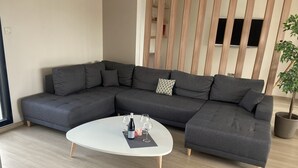 A modern living room with a grey sectional sofa, a white coffee table, and a potted plant. - Between city and ocean house 8per terraces/garden (La Rochelle)