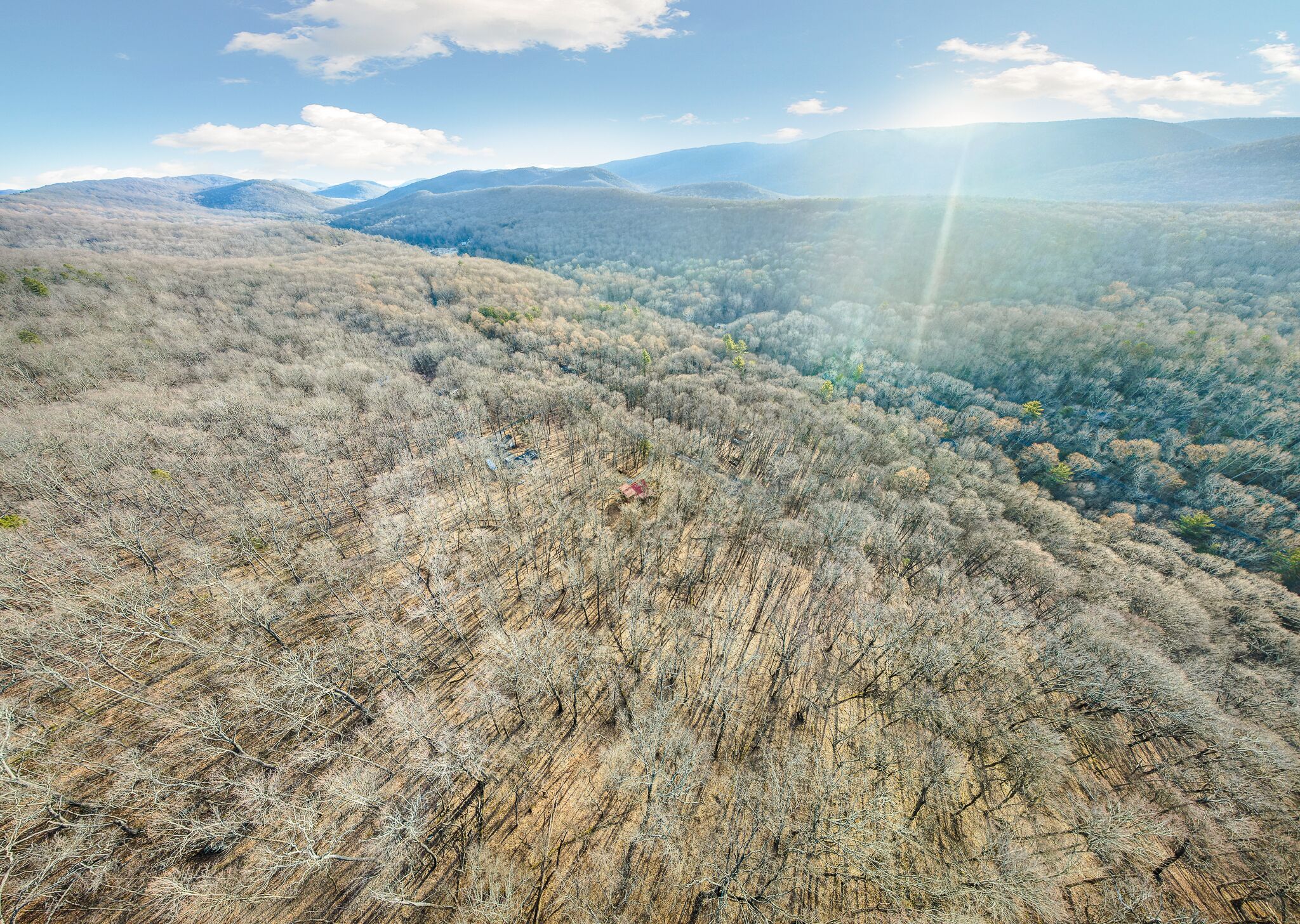 A mountainous landscape with a clear sky and sunlight.
