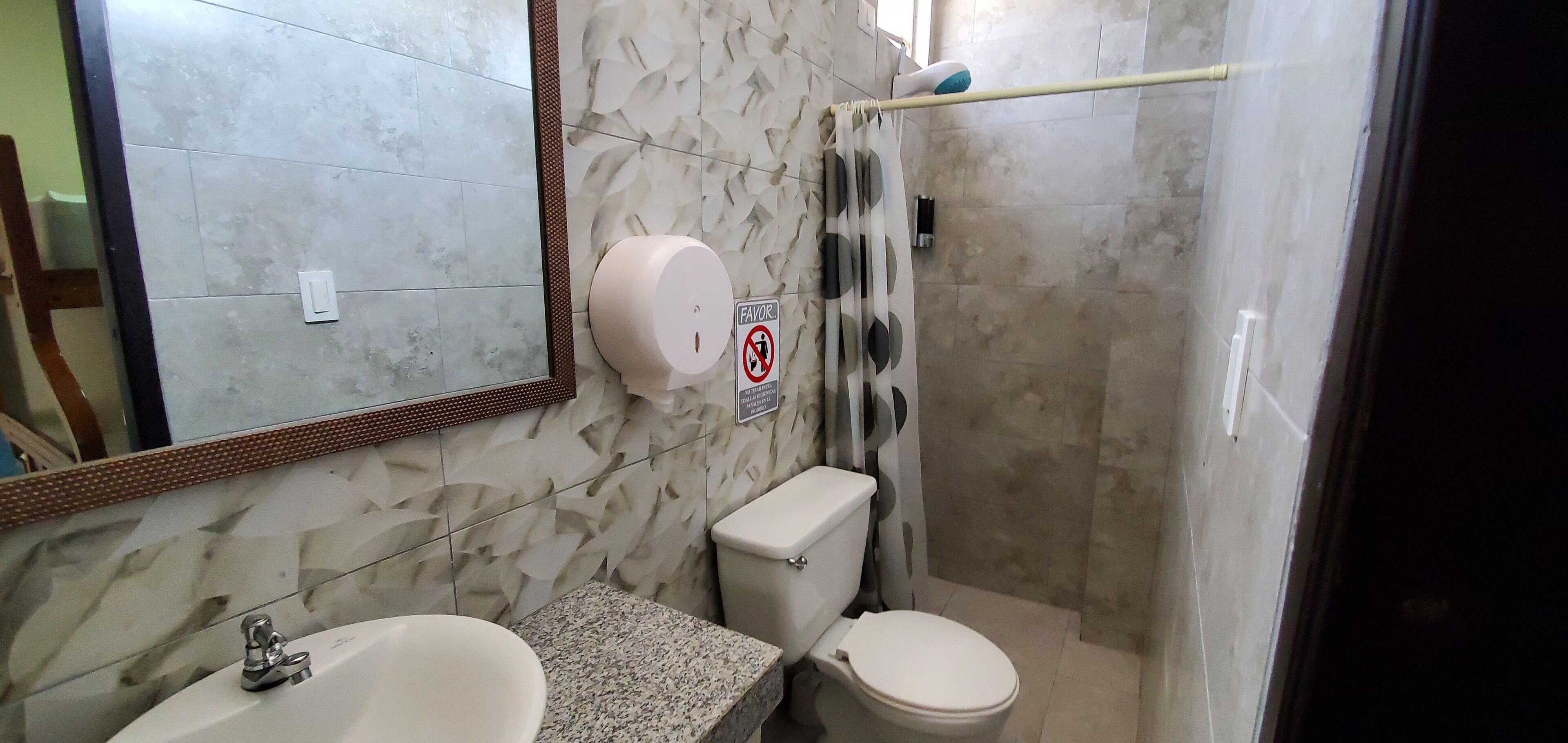 Un baño con lavamanos, inodoro y ducha.