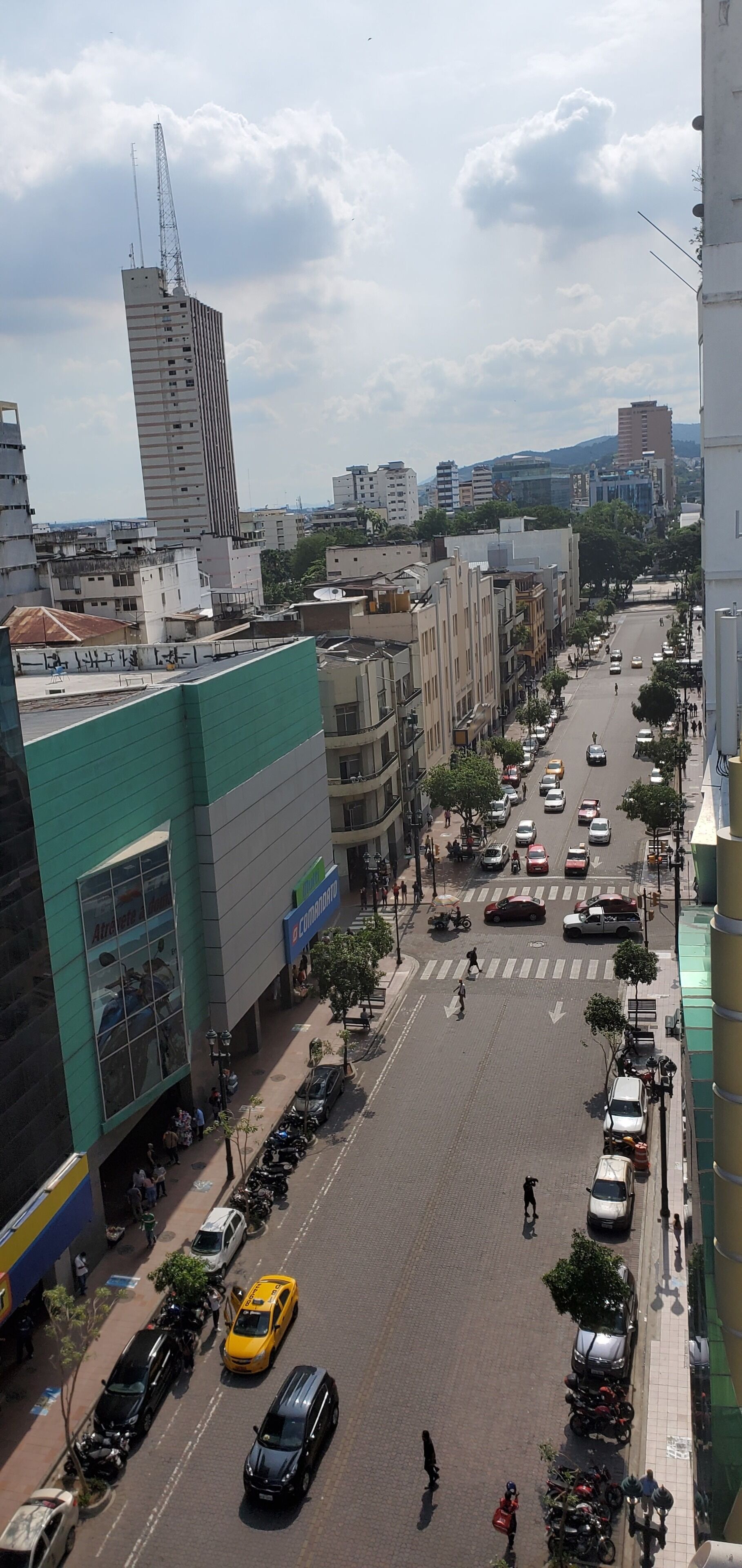 A city street with buildings, vehicles, and pedestrians.