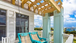 A porch with two turquoise swing chairs and a wooden pergola. - Fun in the Sun: Pool, Hot Tub & Beach (Corolla)