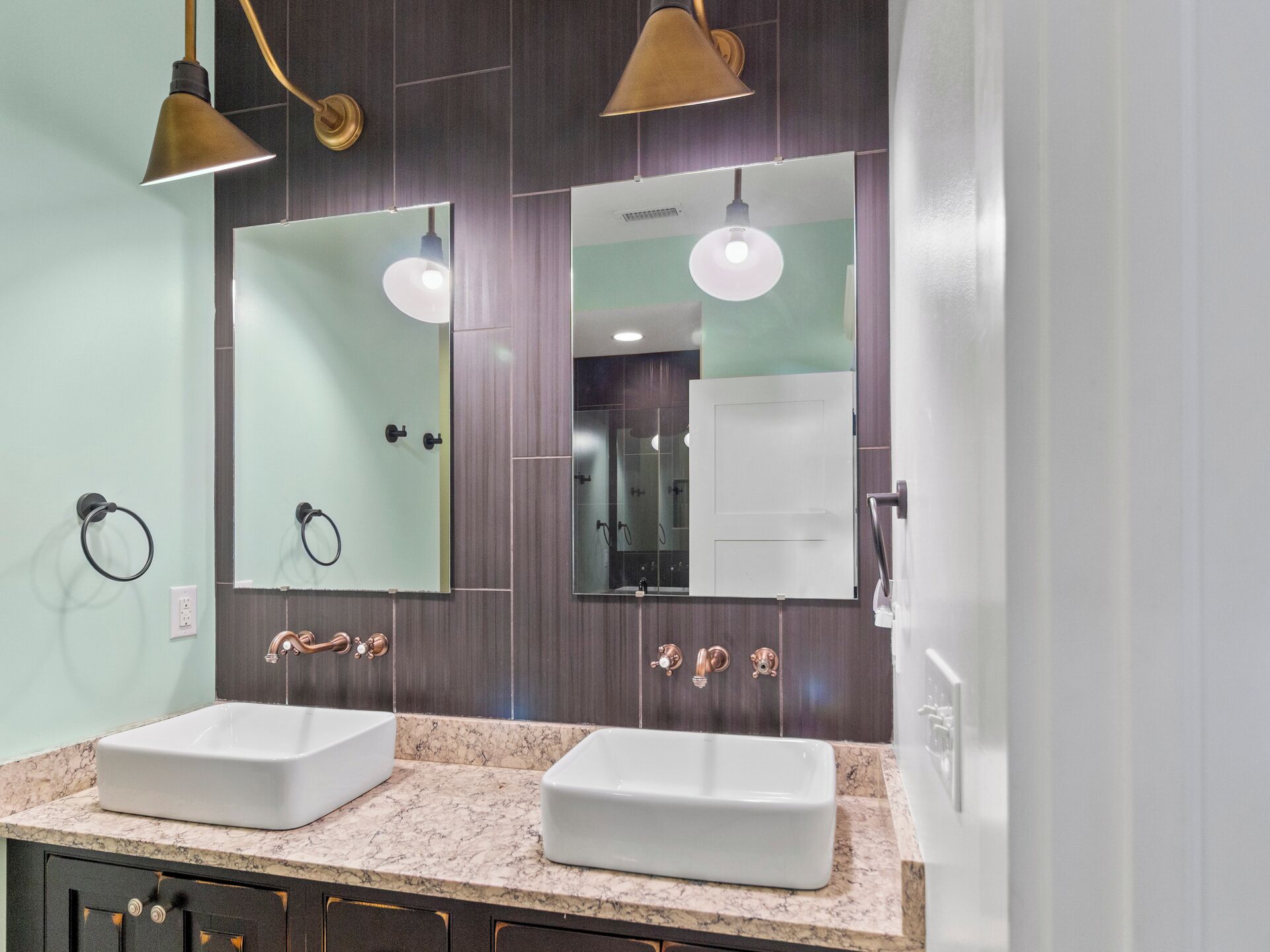 A bathroom with two sinks, a mirror, and a shower area.