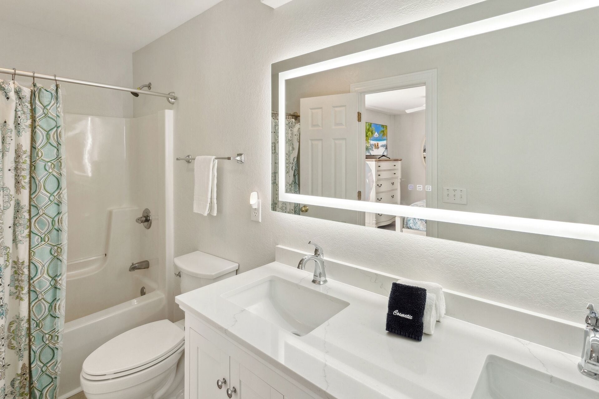 A bathroom with a shower, toilet, and two sinks.