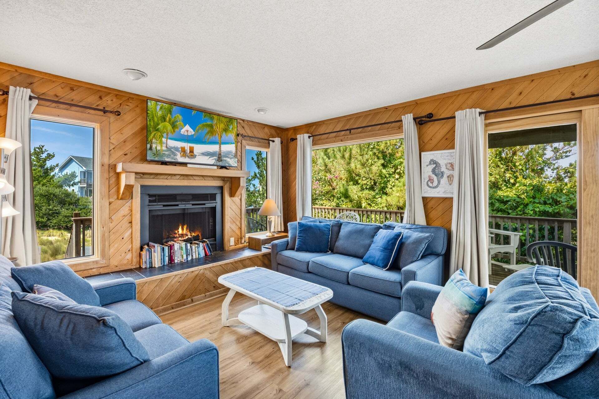 Una sala acogedora con chimenea, un conjunto de sofás y vistas al exterior.