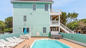 Ein zweistöckiges Gebäude mit Schwimmbad, Außenbereich und einer Treppe, die zu einem Balkon führt.