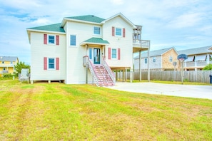 A two-story house with a front porch, a staircase, and a fenced yard.