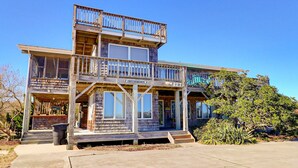 A two-story wooden building with a balcony, a sign reading "Blessed by the Sea," and a number "127" on the front.