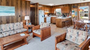 Un acogedor interior de cabaña con sala de estar, comedor y cocina.