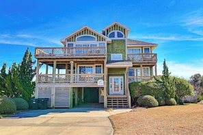 A two-story house with a balcony, a garage, and a well-maintained lawn.