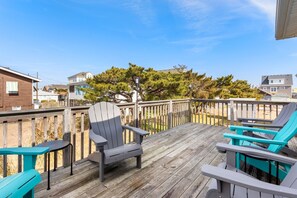 Relax on the deck with a view of the surrounding houses and trees.