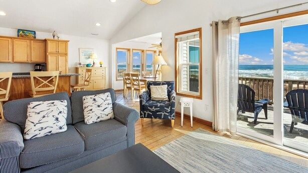 A spacious living area with a sofa, chairs, a dining table, and a view of the ocean. - 5060 Dolphin's Watch * Oceanfront * Elevator (Kill Devil Hills)