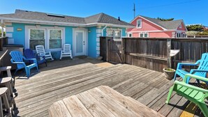 A wooden deck with Adirondack chairs, a small table, and a wooden fence. - Flip Flop Inn * No Stairs * Close to Beach (Kill Devil Hills)