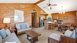 A cozy cabin interior with a living area, dining space, and kitchen. - 5215 Edwards * 3 Min Walk to Beach (Kill Devil Hills)