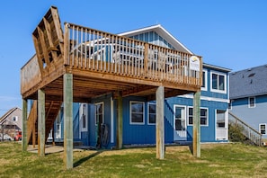 Una casa de dos pisos con un balcón de madera y un letrero que dice 'Seaside Vacations'.