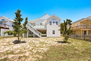 A two-story house with a front porch, a staircase, and a fenced yard.