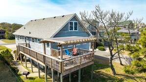 Une maison à deux étages avec une terrasse, une boîte aux lettres et un ciel dégagé.