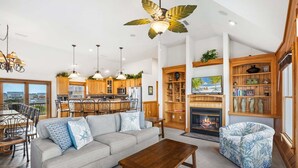 A spacious living area with a sofa, coffee table, and a fireplace. - Ferrari II *SEMI-OCEANFRONT*Pool*HotTub*ArcadeGame (Nags Head)