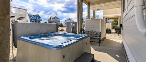 A hot tub in a covered outdoor area with a view of houses in the background.
