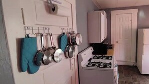 A kitchen with a gas stove, a microwave, and a refrigerator.