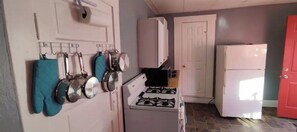 A kitchen with a gas stove, a microwave, and a refrigerator.