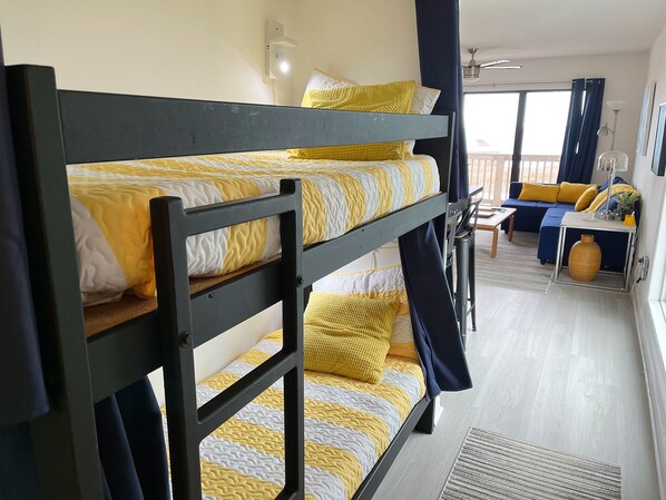 Een slaapkamer met een stapelbed, een bank en een tafeltje.